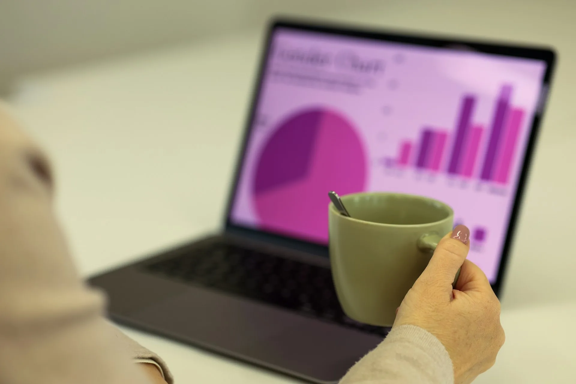 Person looking at a laptop with results charts while working