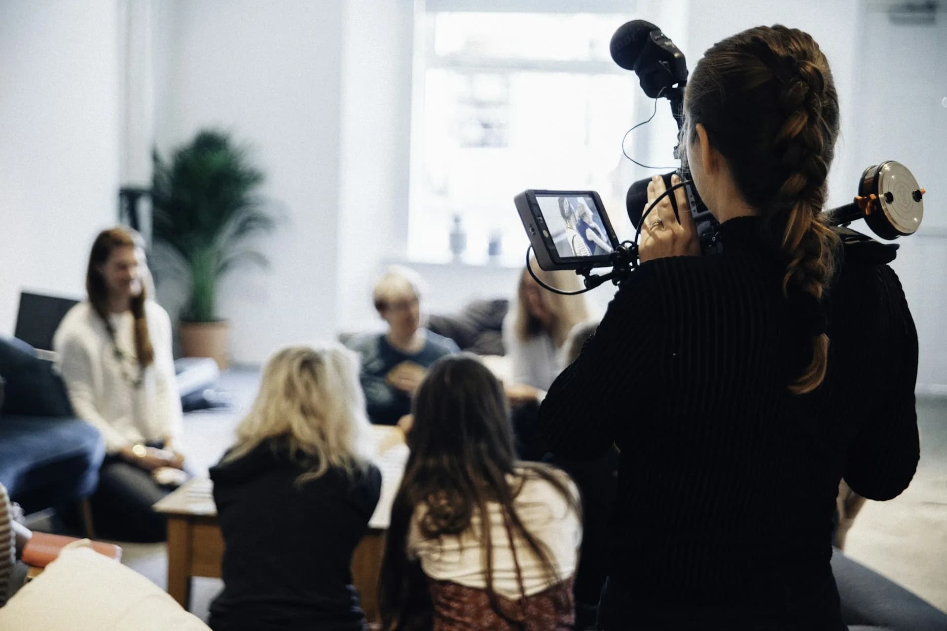 Person with a camera directing someone during a recording