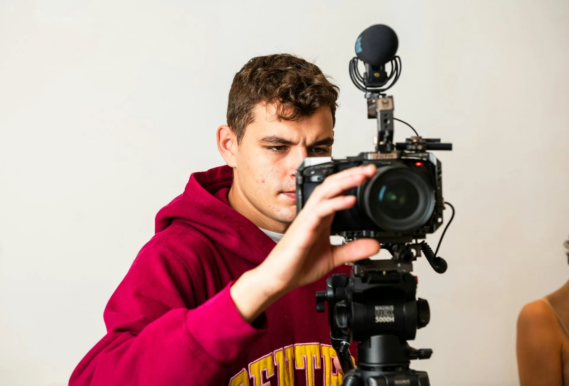 Director de grabación ajustando el encuadre de una cámara de cine en un estudio