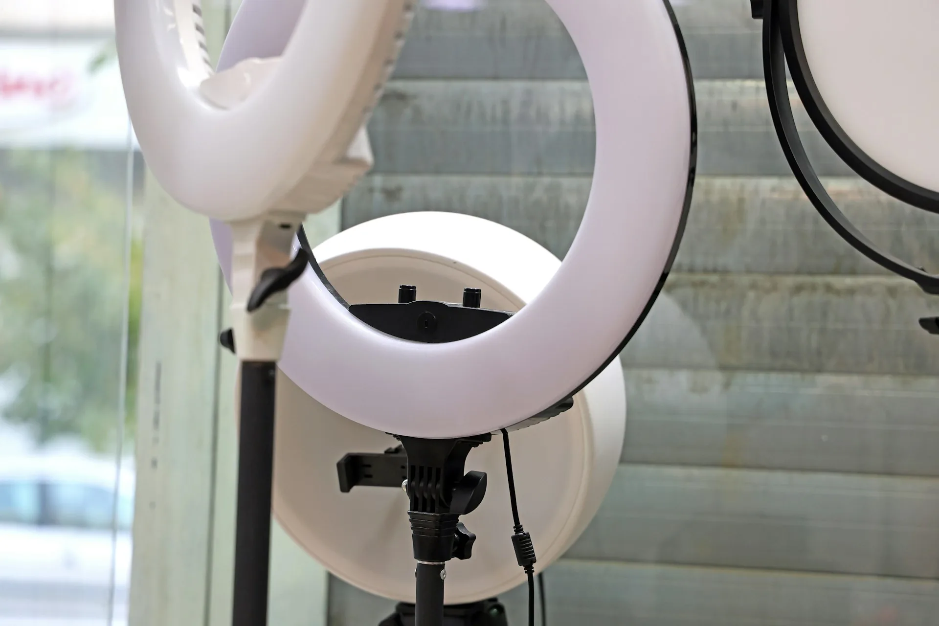 Equipo de iluminación con ring lights junto a ventana en estudio de grabación