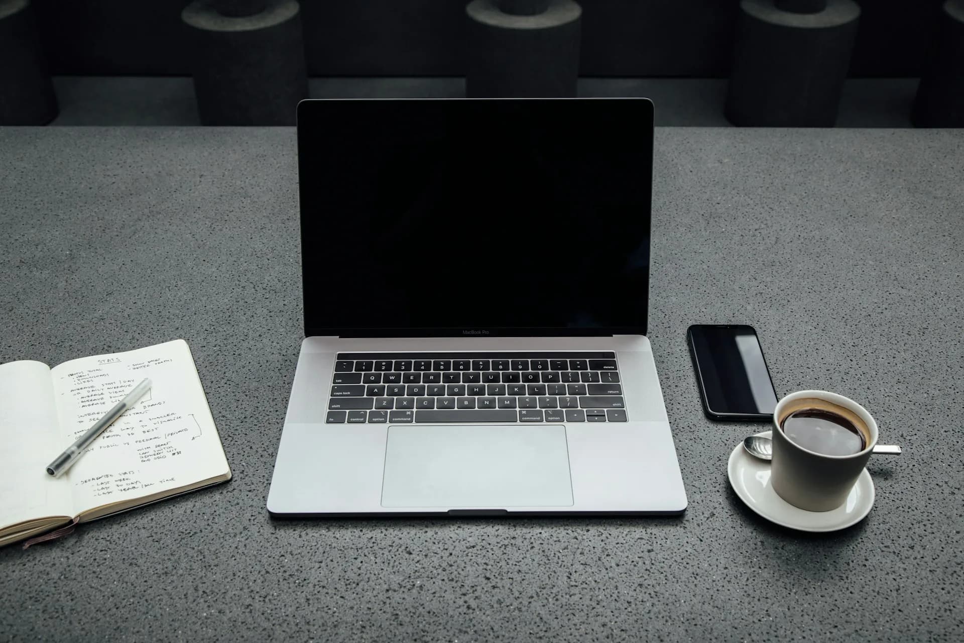 Cuaderno, portátil y café sobre una mesa mientras se escribe un guion de vídeo