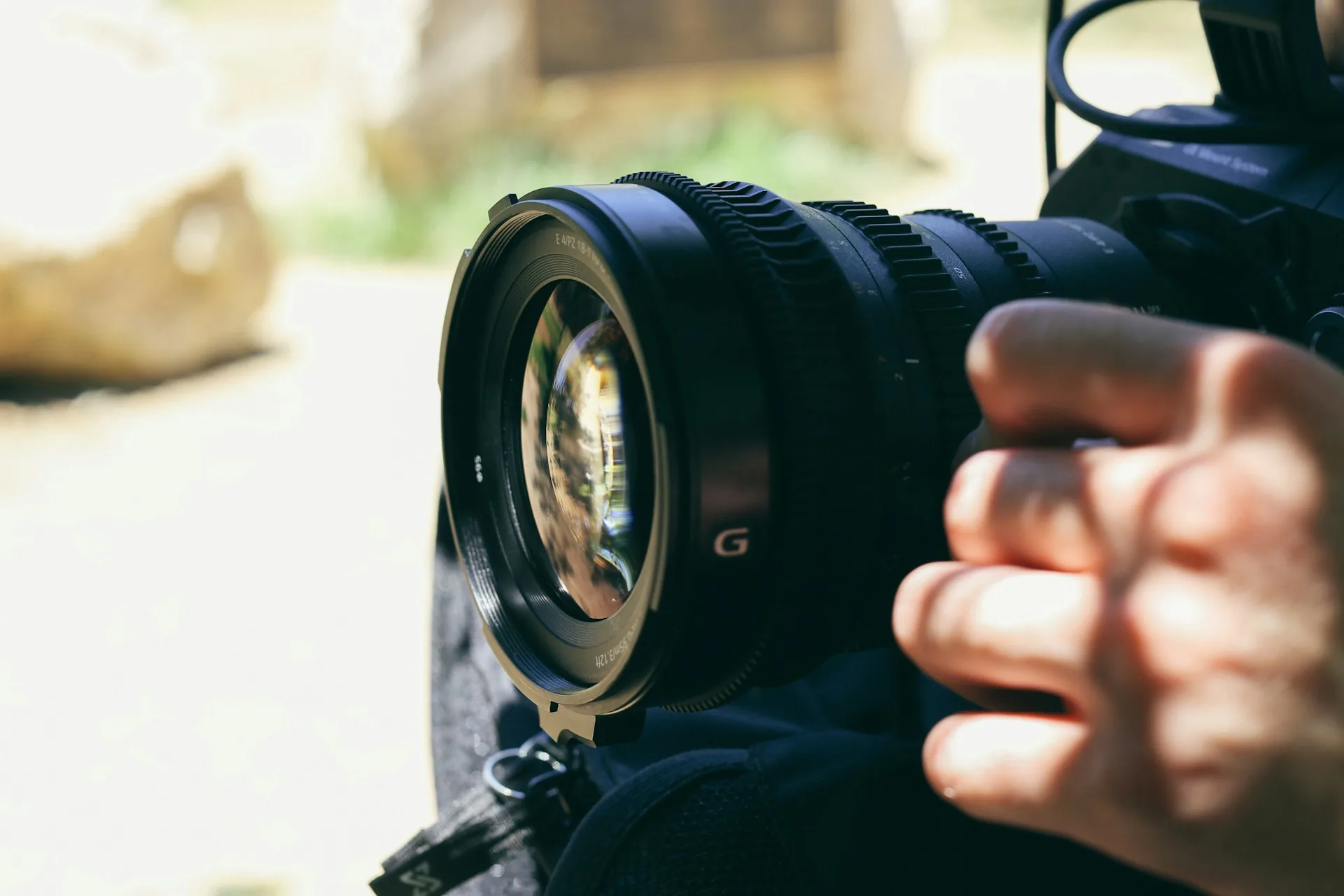 Person holding a black DSLR camera to record content