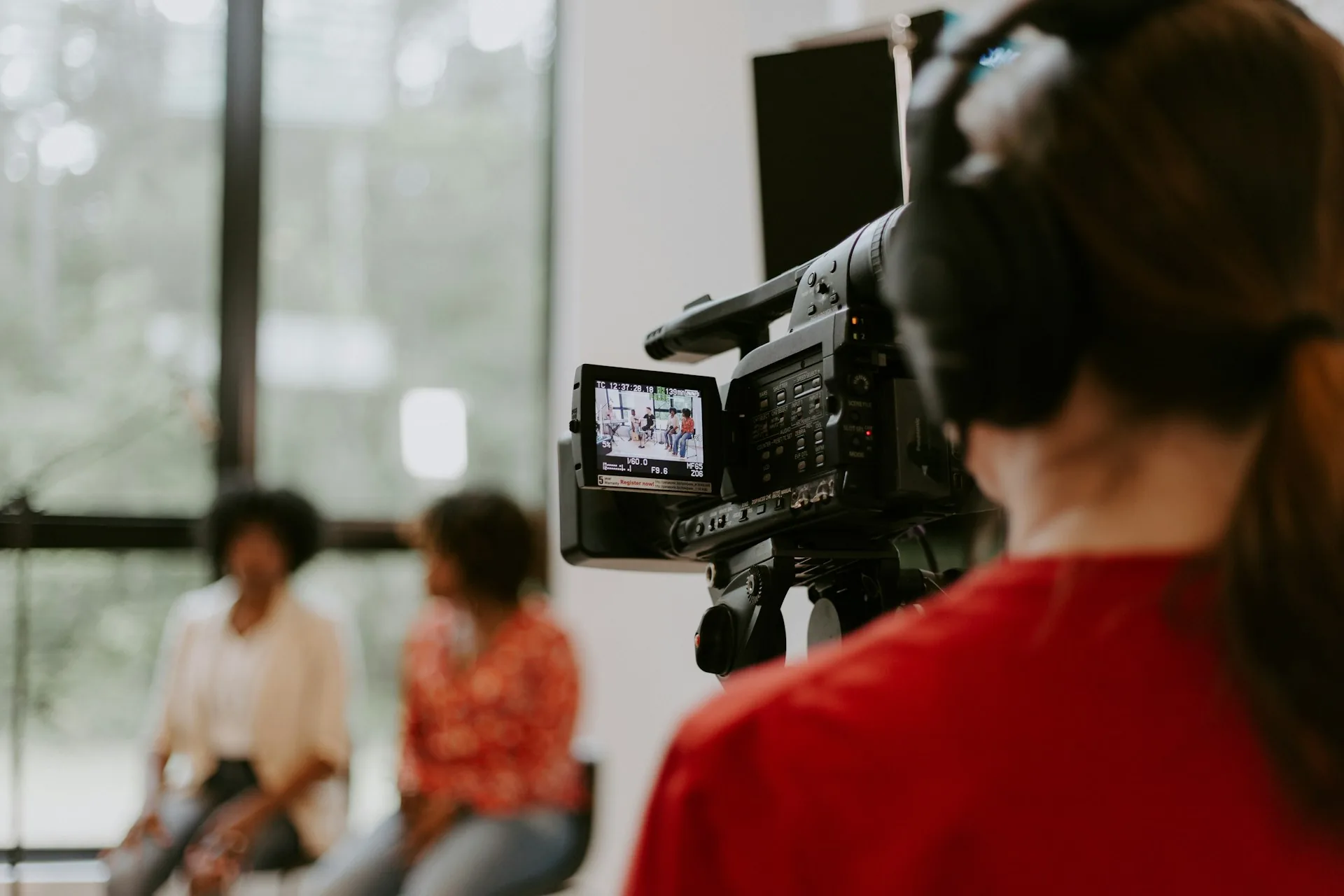 Cámara profesional grabando una entrevista corporativa en oficina con luz natural