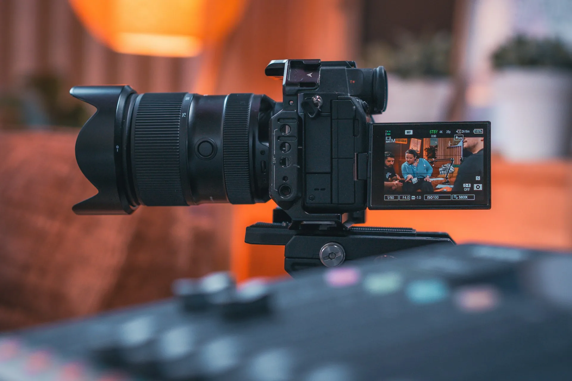 Cámara de vídeo profesional sobre trípode grabando en estudio